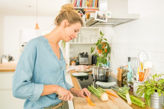 Frau schneidet Gemüse - Gesunde und ausgewogene Ernährung hat großen Einfluss auf Hauterkrankungen