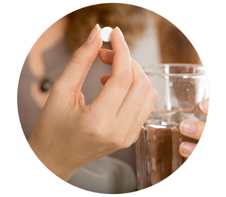 Frau nimmt Tablette zur innerlichen Behandlung von Psoriasis